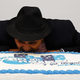 Man pretends to bite into large cake
